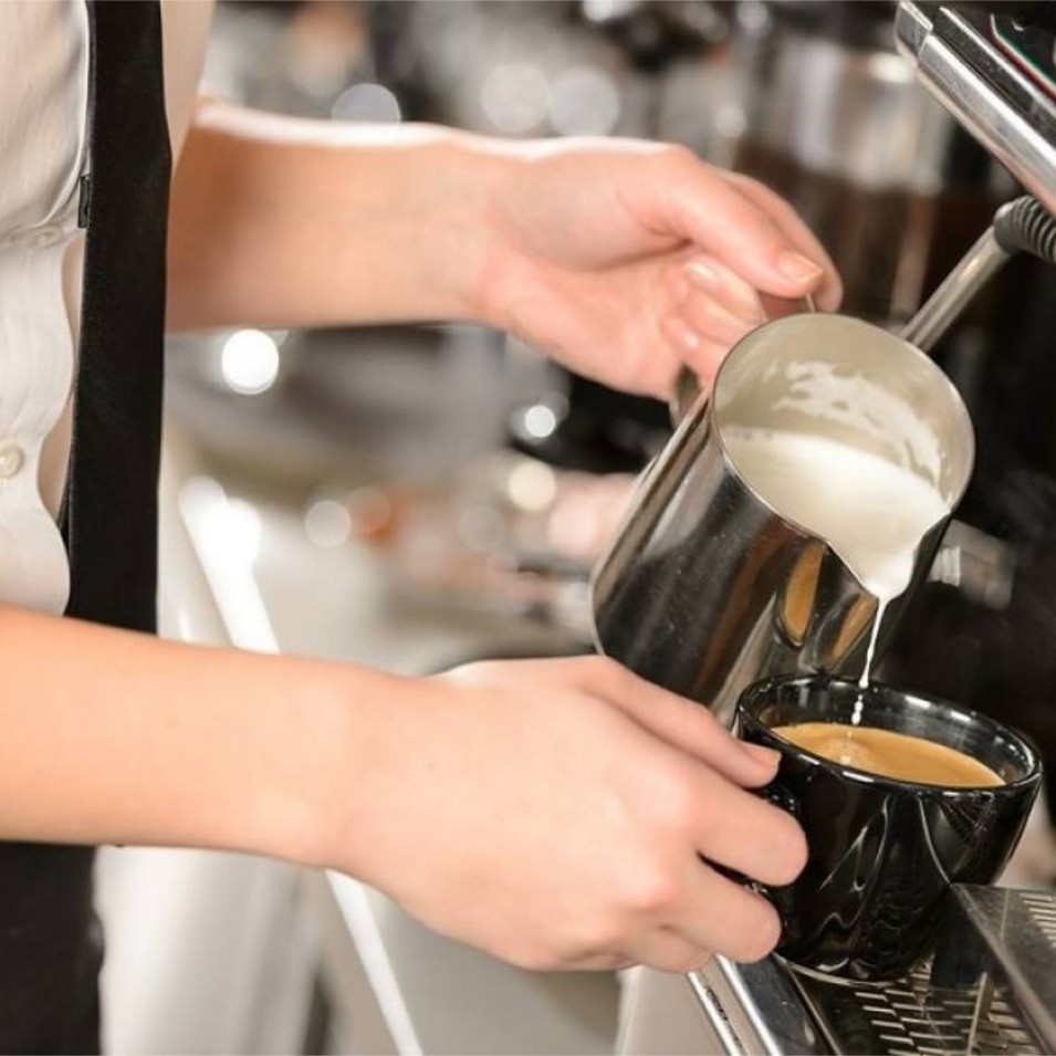 Barista haciendo café con leche en cafetera  expreso